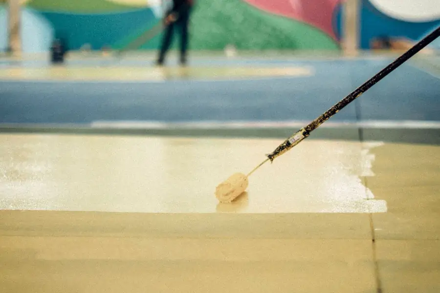 Roller applying a wet resinous floor coating over a concrete slab in Pueblo CO
