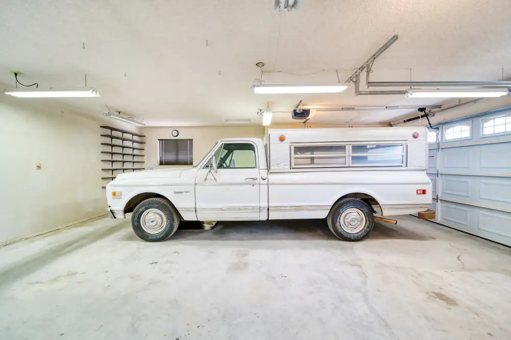 Worn bare concrete garage slab in Pueblo CO with a truck parked on it